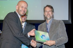 Seniorforsker ved IFE og senterleder for det nye forskningssenteret for nullutslippsløsninger Mobility Zero Emission Energy Systems - MoZEES, Øystein Ulleberg får gratulasjoner og FME-skilt av olje- og energiminister Tord Lien. Foto: Gorm K. Gaare, Norges forskningsråd.